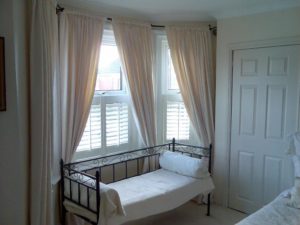 Half window shutters uk example - cafe style shutters in bedroom