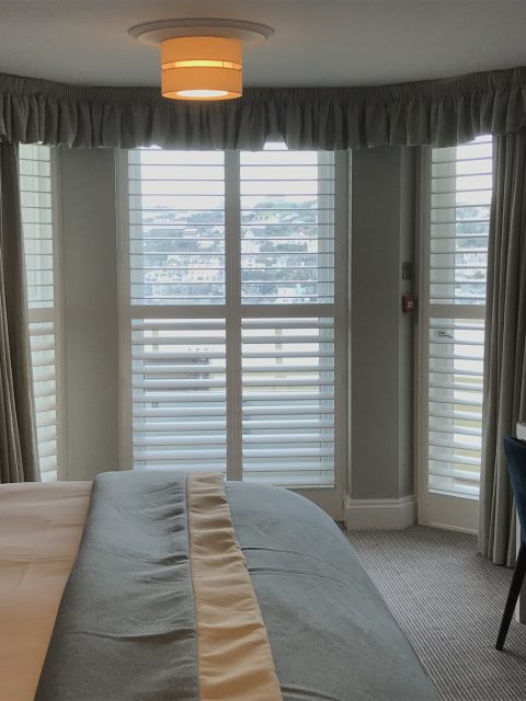 image of a bedroom with full height window shutters